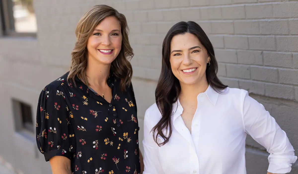 Two engineers smiling outdoors, highlighting teamwork and professionalism in the engineering field.